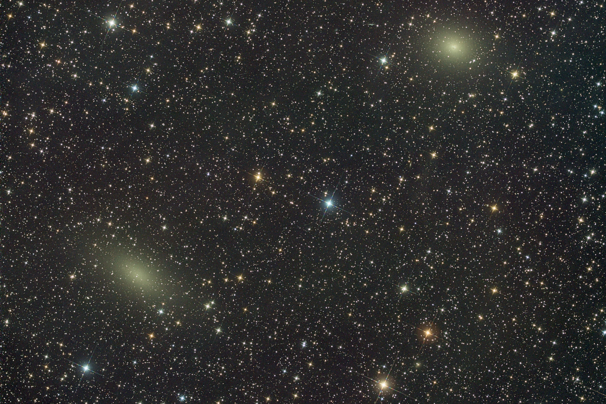 Die Galaxie NGC 147 links unten ist eine kugelförmige Zwerggalaxie etwa 2,58 Mly entfernt im Sternbild Cassiopeia. NGC 147 ist ein Mitglied der lokalen Gruppe von Galaxien und eine Satellitengalaxie der Andromeda-Galaxie (M31). Sie bildet ein physisches Paar mit der nahe rechts gelegenen Galaxie NGC 185, einem weiteren entfernten Satelliten von M31.